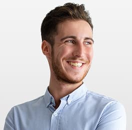 Man with light brown short hair and beard wearing a light blue shirt