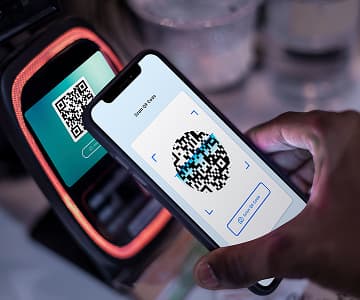 a terminal shows a QR payment link and a phone scans it
